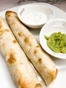 Plate with 2 taquitos, guacamole, and sour cream