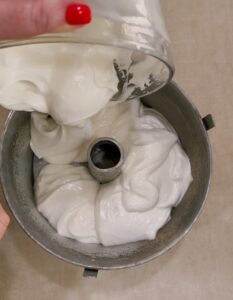 Angel Food Cake batter being scooped into pan
